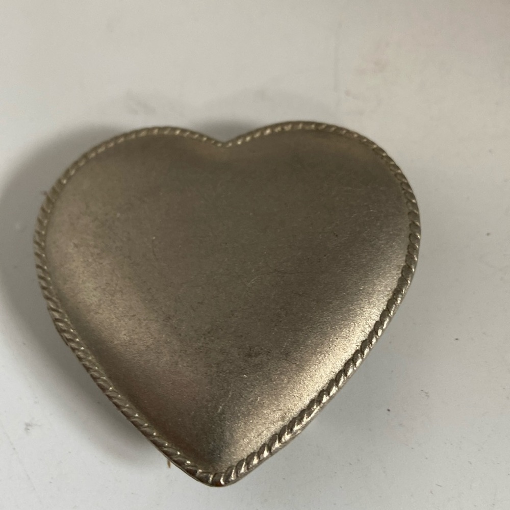 Belt buckle in shape of a heart made of a metal silver color
